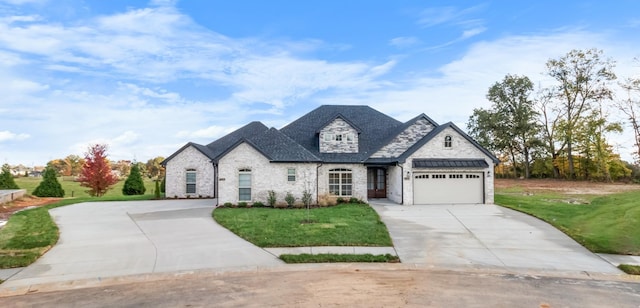 french country style house featuring a front yard and a garage