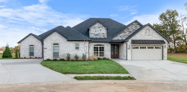 french country inspired facade featuring a garage and a front yard