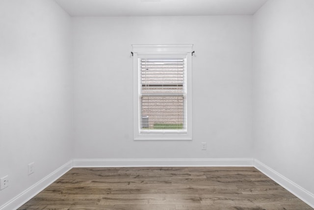 spare room with wood finished floors and baseboards