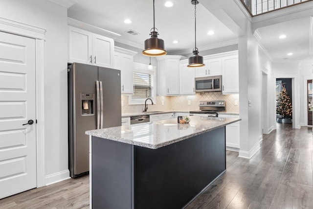 kitchen with stainless steel appliances, a sink, white cabinets, and crown molding