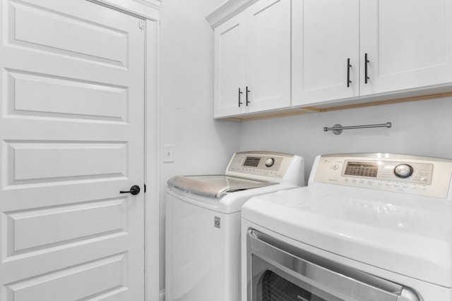 clothes washing area with cabinet space and washer and clothes dryer