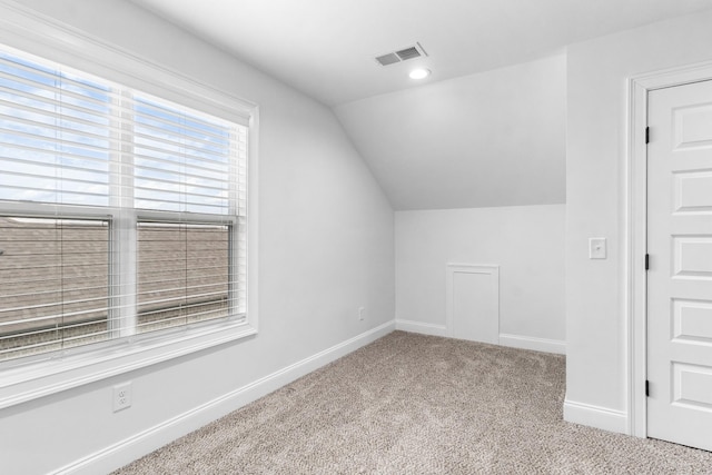 additional living space with lofted ceiling, baseboards, visible vents, and carpet flooring