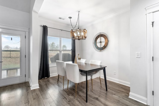 dining room featuring baseboards, dark wood finished floors, visible vents, and crown molding