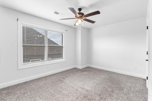 empty room featuring a ceiling fan, carpet, visible vents, and baseboards