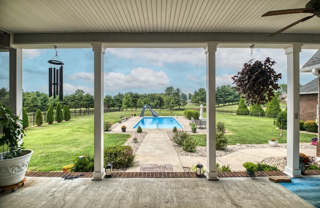 view of pool featuring a lawn, a patio area, ceiling fan, and a water slide