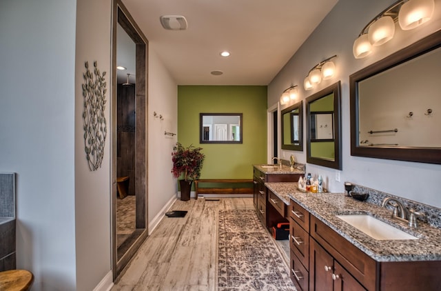 bathroom with a shower, wood-type flooring, and vanity