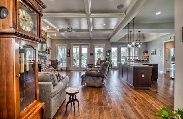 living room with beam ceiling, french doors, dark wood-type flooring, and ceiling fan with notable chandelier