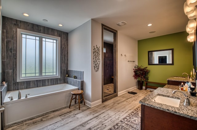 bathroom with separate shower and tub, vanity, and hardwood / wood-style flooring