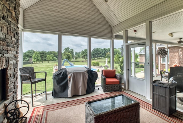 sunroom / solarium featuring vaulted ceiling, plenty of natural light, and wooden ceiling