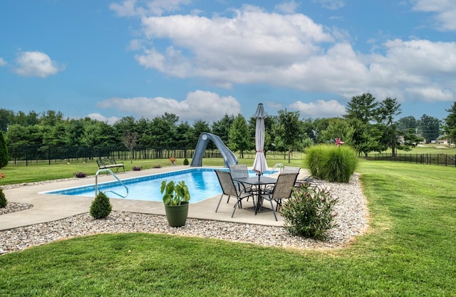 view of swimming pool with a lawn, a diving board, a patio area, and a water slide