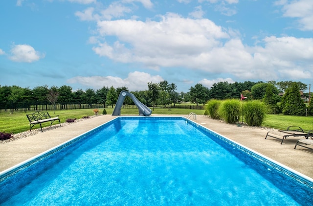 view of pool featuring a lawn, a patio area, and a water slide