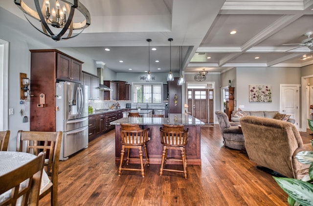 kitchen with dark hardwood / wood-style flooring, light stone counters, a center island, and appliances with stainless steel finishes