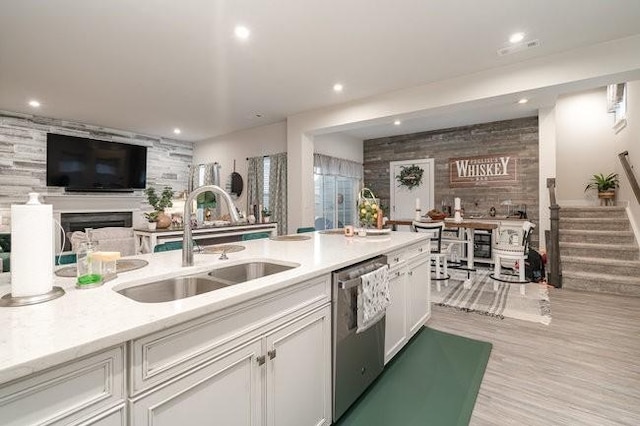 kitchen featuring stainless steel dishwasher, light wood-type flooring, white cabinetry, and sink