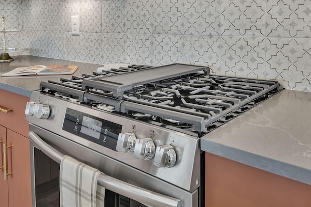 details featuring decorative backsplash and high end stainless steel range