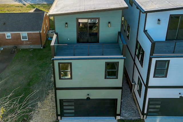 back of house featuring a balcony and a garage