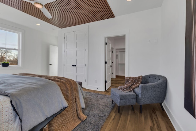 bedroom with ceiling fan, wood-type flooring, and a closet