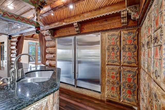 kitchen with sink, dark hardwood / wood-style flooring, beamed ceiling, stainless steel built in fridge, and wood ceiling