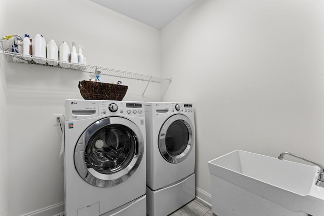 laundry room featuring washing machine and clothes dryer and sink