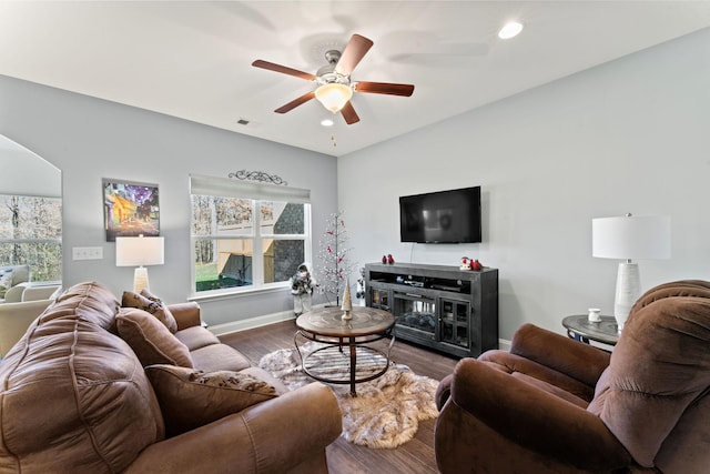 living room featuring ceiling fan and dark wood-type flooring