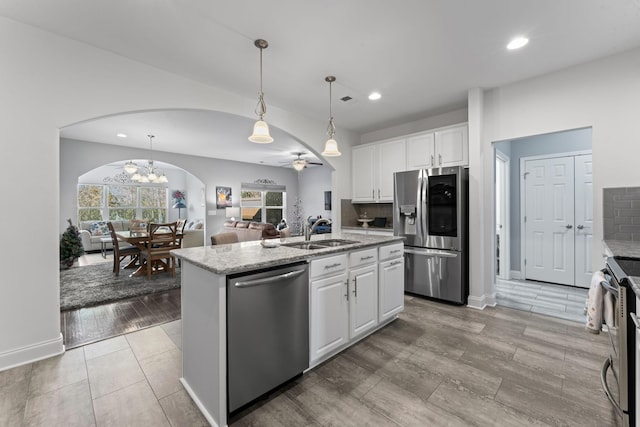 kitchen with sink, white cabinetry, stainless steel appliances, and a kitchen island with sink