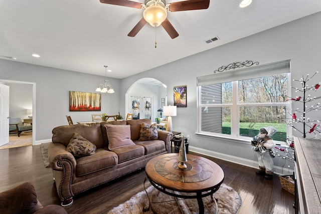 living room featuring french doors, dark wood-type flooring, and ceiling fan with notable chandelier