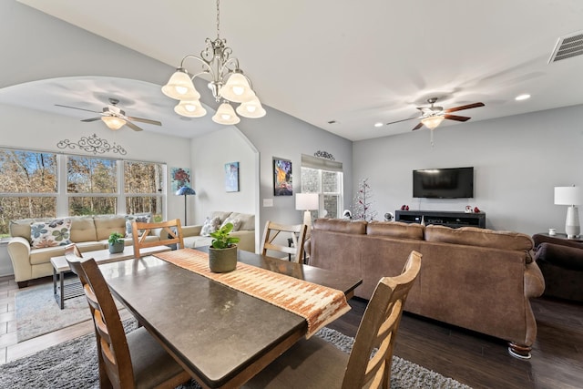 dining area with ceiling fan with notable chandelier and dark hardwood / wood-style flooring