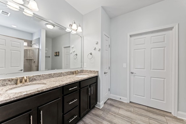 bathroom with a shower with door and vanity