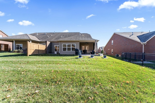 rear view of house featuring central air condition unit, ceiling fan, a yard, and a patio