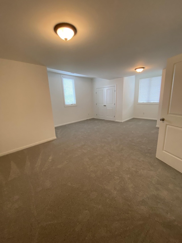 basement featuring dark carpet and a wealth of natural light