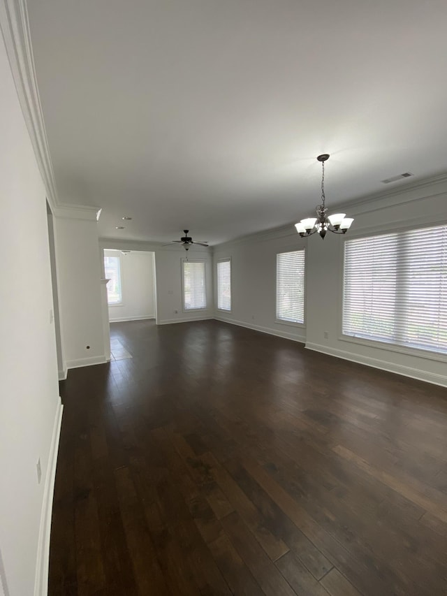 unfurnished living room featuring ceiling fan with notable chandelier, crown molding, and dark wood-type flooring