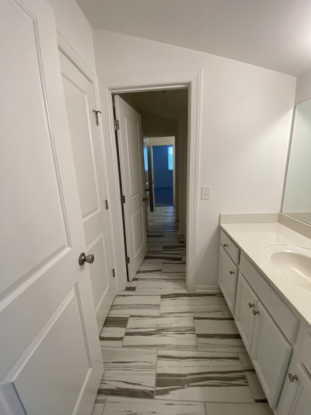 bathroom featuring vanity and lofted ceiling