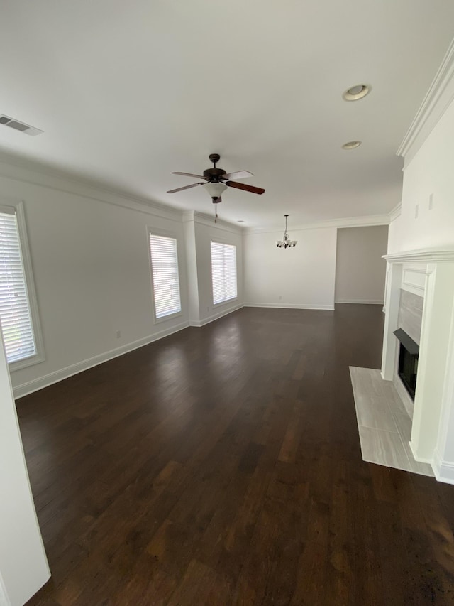 unfurnished living room featuring a fireplace, ceiling fan with notable chandelier, dark hardwood / wood-style floors, and ornamental molding