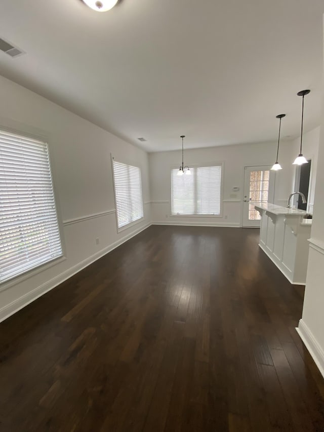 unfurnished living room featuring dark hardwood / wood-style flooring and sink