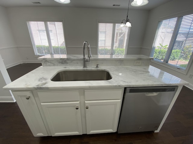 kitchen with white cabinets, stainless steel dishwasher, plenty of natural light, and light stone counters