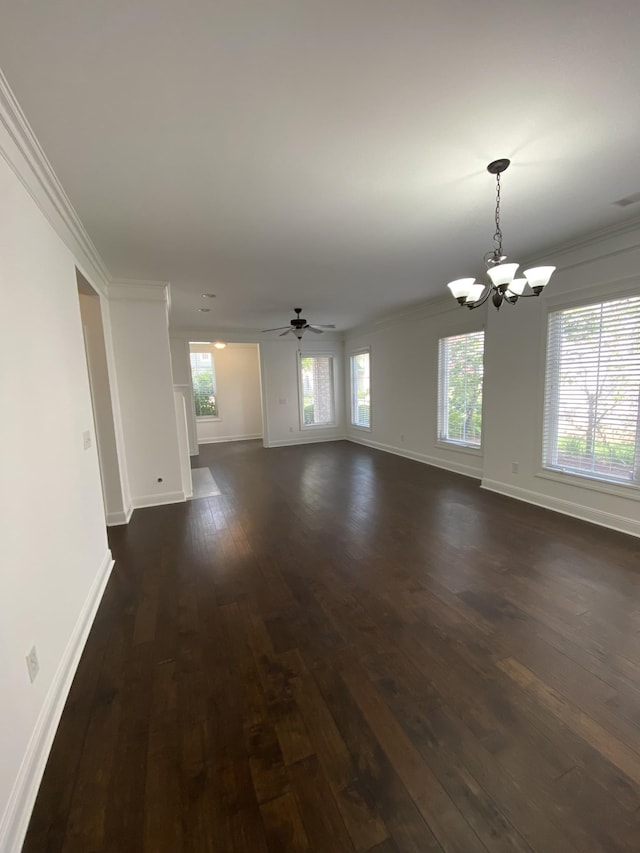 unfurnished living room with dark hardwood / wood-style floors, crown molding, and an inviting chandelier