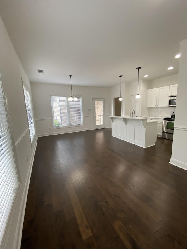 unfurnished living room featuring sink and dark wood-type flooring