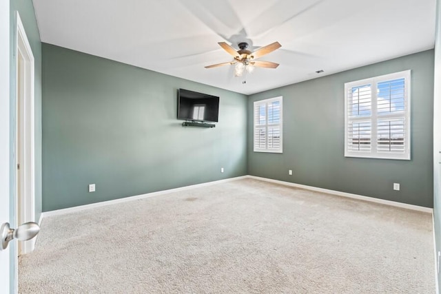 carpeted spare room with plenty of natural light and ceiling fan