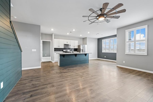 kitchen featuring white cabinets, a kitchen island with sink, hardwood / wood-style flooring, and stainless steel appliances