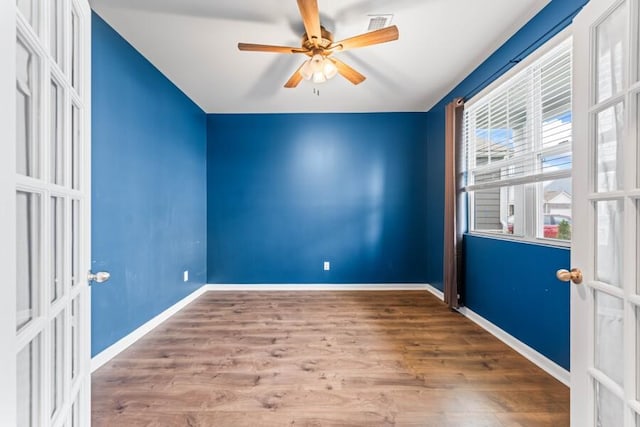 empty room featuring hardwood / wood-style floors, french doors, and ceiling fan