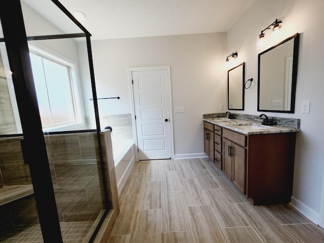 bathroom featuring vanity and independent shower and bath