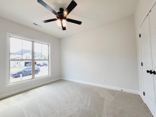 unfurnished room featuring light carpet and ceiling fan