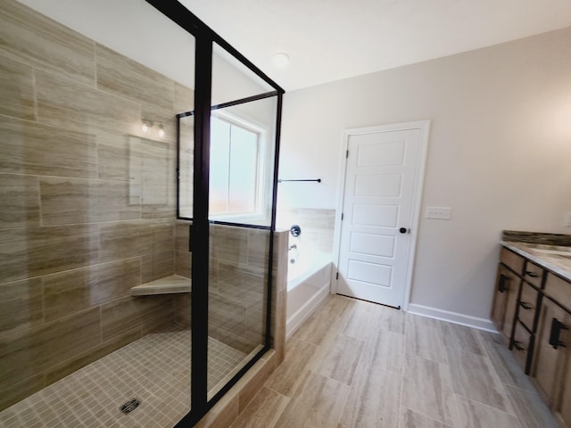 bathroom featuring shower with separate bathtub and vanity