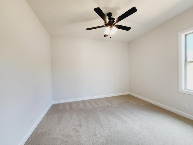 carpeted spare room featuring ceiling fan