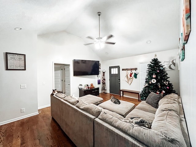 living room with ceiling fan, dark wood-type flooring, and vaulted ceiling