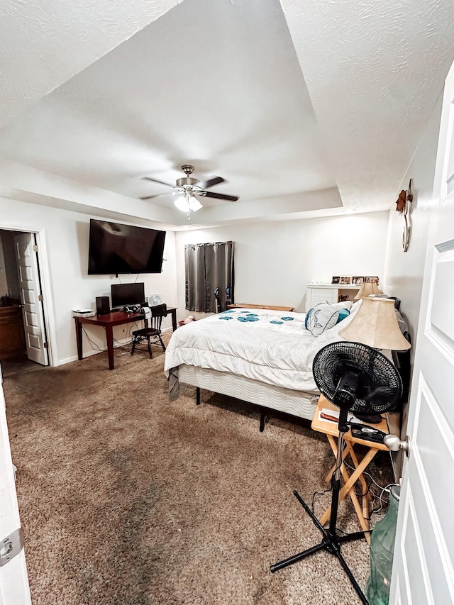 carpeted bedroom featuring ceiling fan and a textured ceiling