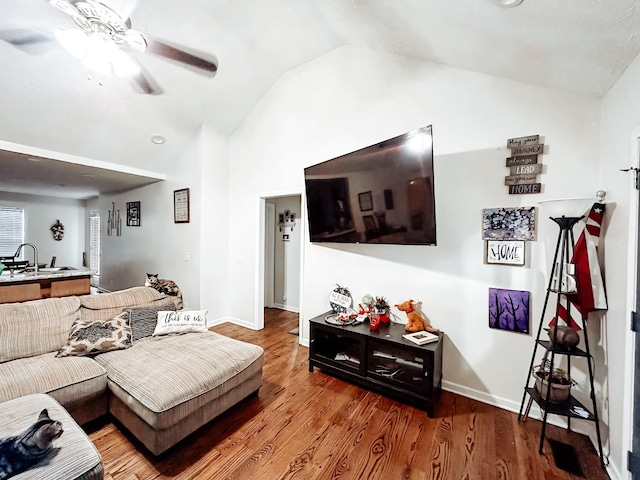 living room with ceiling fan, sink, wood-type flooring, and vaulted ceiling