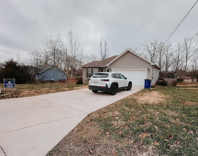 view of side of home featuring a lawn and a garage