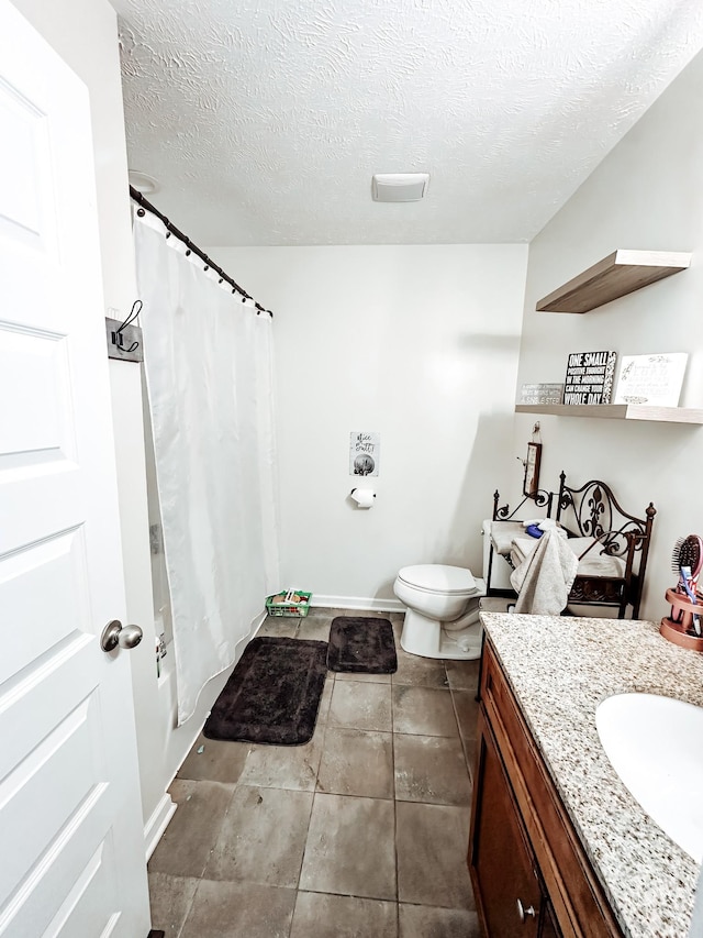 bathroom featuring walk in shower, vanity, a textured ceiling, tile patterned flooring, and toilet