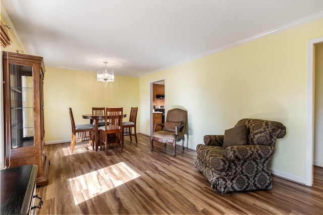 dining area featuring hardwood / wood-style flooring, crown molding, and a chandelier