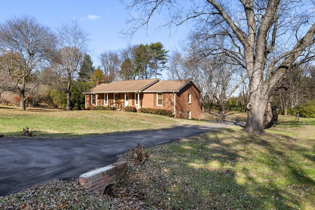 single story home with covered porch and a front yard